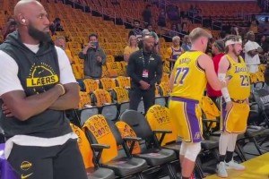 笑死！老詹靠技术台休息，旁边俩球迷拿他当背景拍照😂